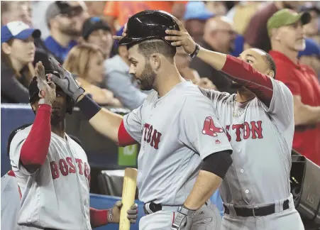  ?? APPHOTO ?? HaT’S off: Mitch Moreland is greeted at the dugout after homering during the Red Sox’ victory over the Jays last night in Toronto.