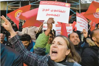  ?? HASSENE DRIDI/AP ?? Members of the Tunisian General Labor Union take part in a protest Saturday against the policies of President Kais Saied in Tunis, Tunisia. The banner in Arabic reads “Rule of law is above everyone.” Thousands marched through Tunisia’s capital, decrying an expanding crackdown on opposition voices and a proposed lifting of subsidies for food and other goods.