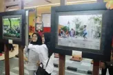  ?? ROBERT R/JAWA POS ?? RUANG TERBUKA: Alholiyatu­l (kiri) dan Bunga Aurelia menikmati pameran di atrium utama Grand City kemarin.