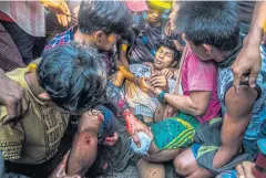  ?? ?? Friends tend to a man shot in the leg during a clash with security forces during a protest on the outskirts of Yangon on March 14, 2021.