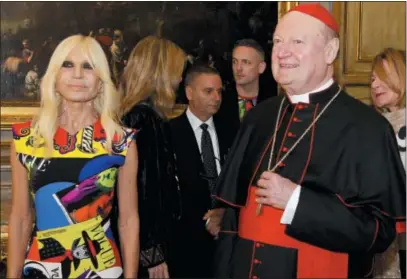  ?? DOMENICO STINELLIS — THE ASSOCIATED PRESS ?? Cardinal Gianfranco Ravasi and designer Donatella Versace arrive at Palazzo Colonna in Rome, Monday. The Vatican is loaning some of its most beautiful liturgical vestments, jeweled miter caps and historic papal tiaras for an upcoming exhibit on...