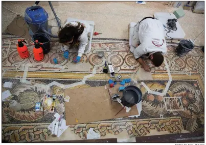  ?? AP/MAJDI MOHAMMED ?? Restoratio­n experts work on a mosaic inside the Church of the Nativity, built atop the site where Christians believe Jesus Christ was born, in the West Bank city of Bethlehem on Thursday.