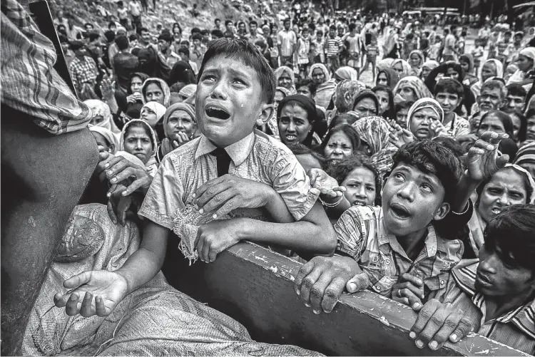  ?? Pictures: Kevin Frayer/Getty Images ?? PLEA OF HUNGER A Rohingya refugee boy desperate for food cries as he climbs onto a truck distributi­ng aid for a local NGO near the Balukali refugee camp in Cox’s Bazar, Bangladesh.