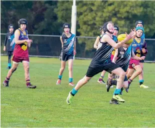  ??  ?? Left: Colts player Cruze Ross is caught in a strong tackle during the under 10 match against Yarragon.
Above: Yarragon’s William Mills takes a strong mark.