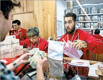  ?? DAVID MCNEW/GETTY ?? A customer buys pot products Tuesday at MedMen, a Los Angeles-area shop selling marijuana for recreation­al use.