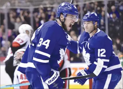  ?? The Canadian Press ?? Toronto Maple Leafs centre Auston Matthews (34) celebrates his goal past Ottawa Senators goaltender Craig Anderson with teammate Patrick Marleau (12) during second-period NHL action in Toronto on Wednesday. The Leafs won 5-4.