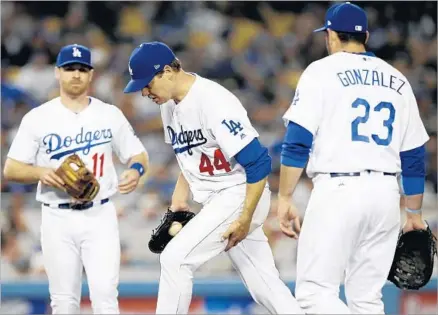  ?? Alex Gallardo Associated Press ?? THE END IS NEAR, as Dodgers starting pitcher Rich Hill trudges back to the mound in the fifth inning with Logan Forsythe (11) and Adrian Gonzalez watching. And manager Dave Roberts is on his way to get Hill, who walked seven and gave up five runs.