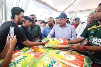  ?? — Bernama photo ?? Anwar visits a booth selling rice at the Central Zone Madani Rakyat programme.