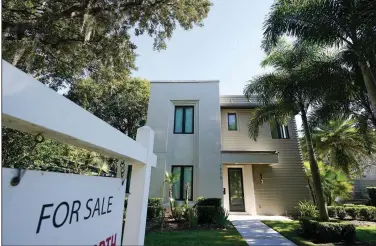  ?? (AP/John Raoux) ?? A home stands for sale in Orlando, Fla., in December. U.S. long-term mortgage rates dropped this week to new lows.