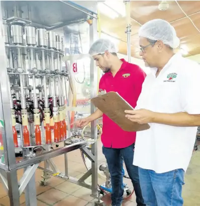  ??  ?? General Manager Drew Gray (left) and Managing Director Andrew Gray inspect the production line at Gray’s Pepper Products Limited in Westmorela­nd.