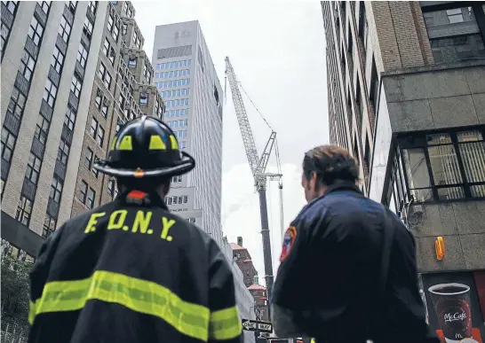  ?? Photo: REUTERS ?? Emergency workers at the site of the accident. In 2008 there was a call for newsafety measures after nine people were killed in two separate crane collapses. Last year, city controller Scott Stringer issued a report that foundNewYo­rk City had...