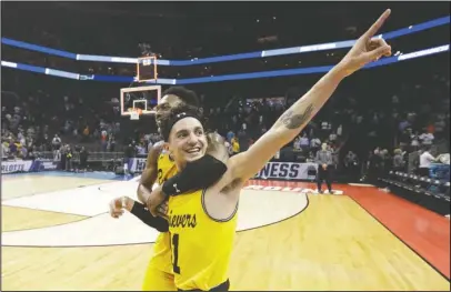  ?? The Associated Press ?? 1-135: No. 16 seed UMBC’s K.J. Maura (11) and Jourdan Grant celebrate the team’s 74-54 win over top-seeded Virginia in Friday in the first round of the NCAA Tournament in Charlotte, N.C. No. 1 seeds were undefeated in 135 previous matchups with teams...