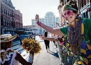  ?? Jon Shapley/Staff photograph­er ?? Stephanie Cook high-fives parade goers during the Mystic Krewe of Aquarius Parade on Feb. 3.