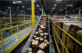  ?? Bloomberg via Getty Images ?? Packages move along a conveyor at an Amazon fulfillmen­t center on Cyber Monday in Robbinsvil­le, N.J., in 2021.