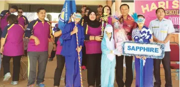  ??  ?? Dr Teo and Haimisah (third and fifth right) in a photocall with the marching team of Sapphire House.