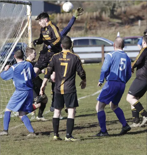  ??  ?? Adam Doyle of Carnew AFC rises highest to clear his lines against Roundwood.