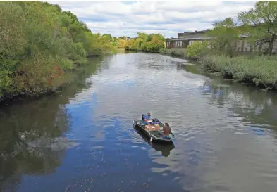  ?? MIKE DE SISTI / MILWAUKEE JOURNAL SENTINEL ?? Nick Hayden (left) and Evan Murdock with Montgomery Associated test the dissolved oxygen levels on the Kinnickinn­ic River just north of the E. Lincoln Ave. bridge in Milwaukee.