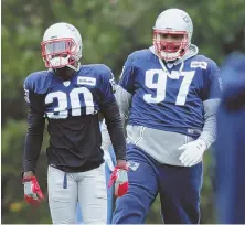  ?? STAFF PHOTO BY JOHN WILCOX ?? DEFENSIVE POSTURE: Defensive lineman Alan Branch (97) and safety Duron Harmon stretch at the start of yesterday’s practice.
