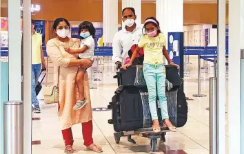  ?? Clint Egbert/Gulf News ?? ■ Indian expat Neethu Raveendran, her husband Sudheesh Kumar and their children arrive at the Dubai Internatio­nal Airport Terminal 3 yesterday.