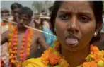  ?? — AFP ?? Devotees with steel rod piercings through their cheeks stand as they taking part in a procession to honour the goddess Maha Mariamman to mark Mother’s Day in Amritsar on Sunday.