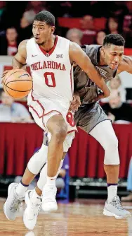  ?? [PHOTO BY STEVE SISNEY, THE OKLAHOMAN] ?? Oklahoma’s Christian James works around Northweste­rn’s Anthony Gaines during a Dec. 22, 2017, game in Norman.