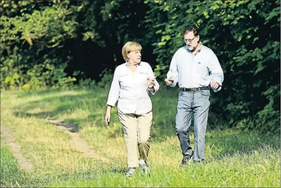  ?? TOBIAS SCHWARZ / AFP ?? Merkel i Rajoy el dia que van fer un tomb pel Camí, un 31 d’agost del 2015