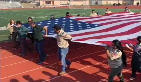  ?? RECORDER PHOTO BY ESTHER AVILA ?? Scout Troop 132, under Advisor Don Valdez, walk down the track of Jacob Rankin Stadium with a large American flag during the 2021 Buck Shaffer Banda-rama.