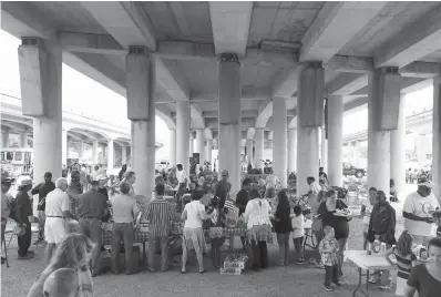  ?? Photos by Rod Aydelotte/ Waco Tribune-Herald via AP ?? below leftChurch Under the Bridge volunteers feed the needy on July 1, 2017, under Interstate 35 during the church’s weekly service in Waco. The Texas Department of Transporta­tion’s $300 million plan to widen the interstate to four lanes in both directions means the Church Under The Bridge will have to find a new location, and years could pass before its return.