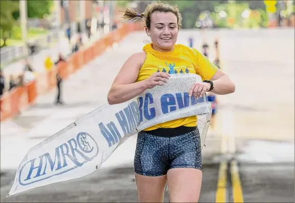  ?? James Franco / Special to the Times Union ?? Caitie Meyer is the first woman to cross the finish line at the CDPHP Workforce Team Challenge on Thursday in Albany. She ran 20:16 for the 3.5 miles.