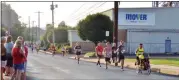  ?? BOB KEELER — MEDIANEWS GROUP ?? Runners in the Moyer Indoor/Outdoor 5K are cheered on as they pass the Moyer headquarte­rs and prepare to turn onto Reliance Road in Souderton.