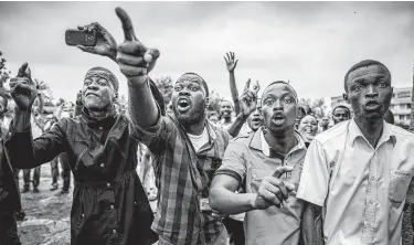  ?? Luis Tato / AFP / Getty Images ?? Protesters waiting to cast their ballots demonstrat­e Sunday in Kinshasa, Congo. Three opposition stronghold­s, Beni and Butembo in the east and Yumbi in the west, were barred from participat­ing.