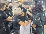  ??  ?? Hamilton celebrates with his team in Bahrain