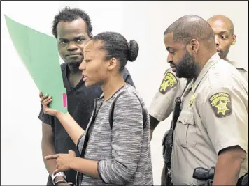  ?? HENRY TAYLOR / HENRY.TAYLOR@AJC.COM ?? Basil Eleby is escorted by his public defender and two Fulton County Sheriff’s office officers into the courtroom of presiding Judge James Altman at the Fulton County Jail in Atlanta on Saturday.