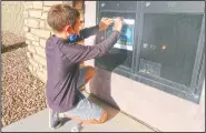  ?? (AP/Cheyanne Mumphrey) ?? Dylan, 8, tapes up flyers in his neighborho­od. The flyers promoted his third food drive since October in response to the coronaviru­s pandemic.