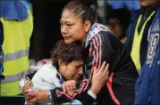  ?? REBECCA BLACKWELL / AP ?? Family members in Mexico City’s Roma Norte neighborho­od wait Friday for news of relatives outside a quake-collapsed seven-story building. The search for quake survivors was in its fourth day.