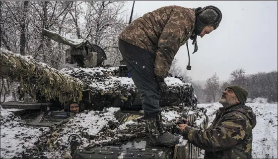  ?? DANIEL BEREHULAK — THE NEW YORK TIMES ?? Commander Poltava, right, directs members of his tank battalion, which is equipped with Soviet-era tanks, as they prepare to head toward the front line near Bakhmut, Ukraine, this month. Ukrainian commanders, struggling to get by with aging, outdated Soviet-era tanks, have expressed frustratio­n with the slow pace of deliveries of promised Western tanks.