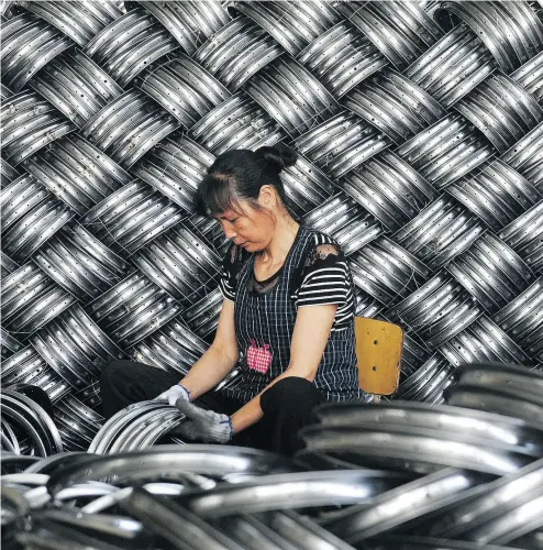  ?? AFP / GETTY IMAGES ?? A worker checks wheel hubs of baby carriages that will be exported at a factory in Hangzhou, China.