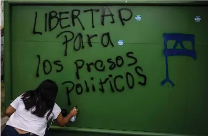  ?? ?? A woman spray-paints ‘Freedom for political prisoners’ in Managua, Nicaragua, in 2020. Photograph: Inti Ocón/AFP/Getty Images