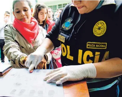  ?? AFP ?? Un policía peruano le toma la huella a una migrante venezolana, el miércoles, en la sede de Interpol en Lima. Colombia, Perú, Chile, Ecuador y Argentina son los principale­s destinos de quienes dejan Venezuela.