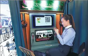  ?? FENG YONGBIN / CHINA DAILY ?? A woman connects her mobile phone with a mini-karaoke system in a shopping mall in Beijing.