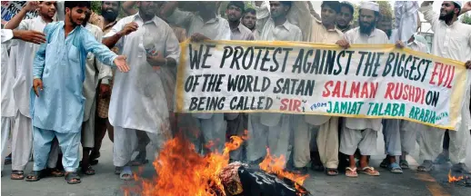  ?? ?? Fiery hate: Protesters burn an effigy of Salman Rushdie in Multan, Pakistan, after the author was knighted in 2007
