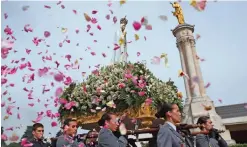  ??  ?? In this file photo, worshipper­s throw flower petals at the statue of the Our Lady of Fatima as it is carried at the Our Lady of Fatima shrine, in Fatima, central Portugal.