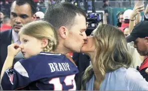  ?? PATRICK SEMANSKY / AP ?? New England Patriots quarterbac­k Tom Brady kisses his wife Gisele after leading the Pats to a 34-28 overtime victory over the Atlanta Falcons in Super Bowl LI in Houston on Sunday. At left is their daughter, Vivian.