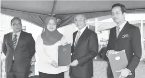 ??  ?? ROZMAN menyampaik­an sijil penghargaa­n kepada Maszanah Sazali, Setiausaha Majlis Bersama Jabatan dan wakil pekerja bagi Gred 29-38. Turut kelihatan Azhar (kanan) dan Bashir.