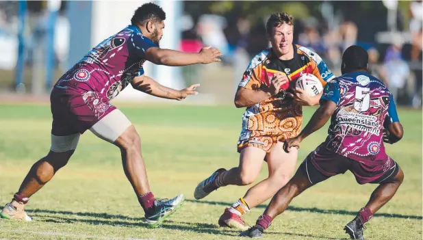  ??  ?? TOUGH CONTEST: J’Maine Hopgood, for Wenlock River Stallions, takes on Mackay opponents in the Queensland Murri Carnival grand final at Townsville Sports Reserve.