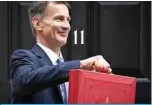  ?? —AFP ?? LONDON: Britain’s Chancellor of the Exchequer Jeremy Hunt poses with the red Budget Box as he leaves 11 Downing Street in central London on March 15, 2023.