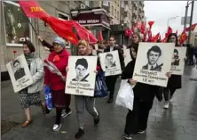  ?? Alexander Zemlianich­enko/Associated Press ?? People march Wednesday with flowers and portraits of those who were killed during the 1993 bloody clashes between government forces and supporters of the rebellious parliament during a rally marking the 30th anniversar­y of the events in Moscow.