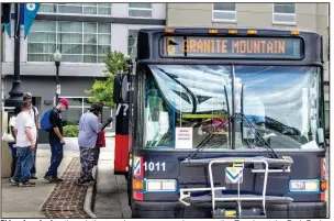  ?? (Arkansas Democrat-Gazette/Stephen Swofford) ?? Riders board a bus through the rear door as a coronaviru­s precaution Tuesday at the Rock Region Metro Transit Center in downtown Little Rock. Rides have been free for weeks, but fares are being reinstated, and some workers who were laid off by the transit agency in May are returning to work.