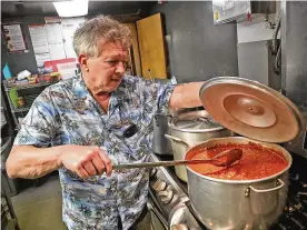 ?? BILL LACKEY / STAFF ?? Fred Stegner, president of the Springfiel­d Soup Kitchen, stirs the pasta sauce being served for dinner at the kitchen Monday night.