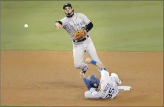  ?? Alex Gallardo Associated Press ?? WITH THE SHIFT ON, Rockies third baseman Nolan Arenado takes the throw at second base to force Cody Bellinger and goes to first to complete a double play on Max Muncy.